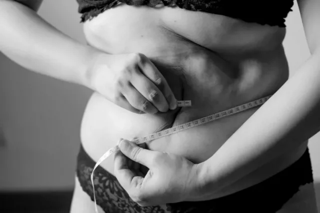 woman measuring belly fat